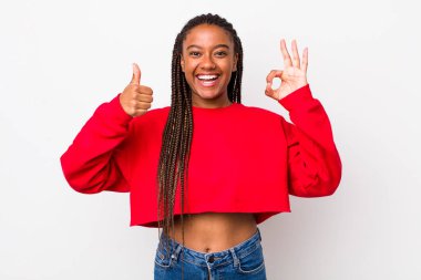 afro pretty woman feeling happy, amazed, satisfied and surprised, showing okay and thumbs up gestures, smiling