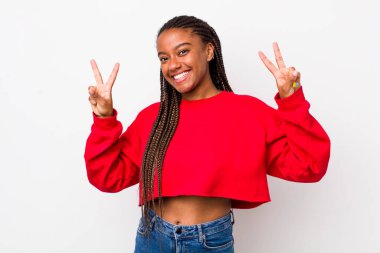 afro pretty woman smiling and looking happy, friendly and satisfied, gesturing victory or peace with both hands