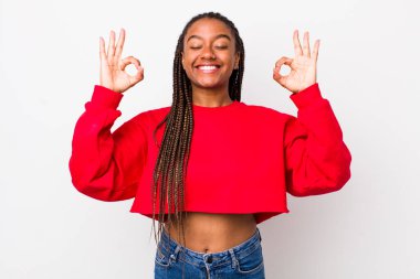 afro pretty woman looking concentrated and meditating, feeling satisfied and relaxed, thinking or making a choice