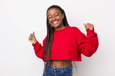 afro pretty woman smiling, feeling carefree, relaxed and happy, dancing and listening to music, having fun at a party