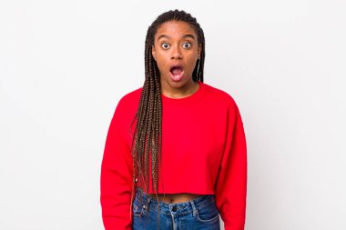 afro pretty woman looking very shocked or surprised, staring with open mouth saying wow