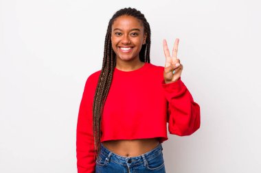 afro pretty woman smiling and looking friendly, showing number two or second with hand forward, counting down