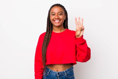 afro pretty woman smiling and looking friendly, showing number three or third with hand forward, counting down