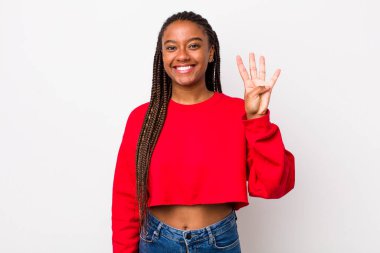 afro pretty woman smiling and looking friendly, showing number four or fourth with hand forward, counting down
