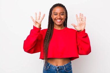 afro pretty woman smiling and looking friendly, showing number nine or ninth with hand forward, counting down