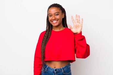 afro pretty woman smiling and looking friendly, showing number five or fifth with hand forward, counting down