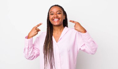 afro pretty woman smiling confidently pointing to own broad smile, positive, relaxed, satisfied attitude
