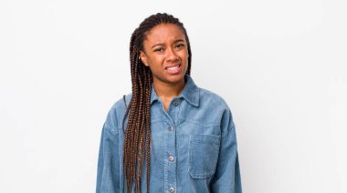 afro pretty woman feeling puzzled and confused, with a dumb, stunned expression looking at something unexpected