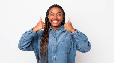 afro pretty woman smiling broadly looking happy, positive, confident and successful, with both thumbs up