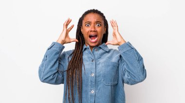 afro pretty woman screaming with hands up in the air, feeling furious, frustrated, stressed and upset