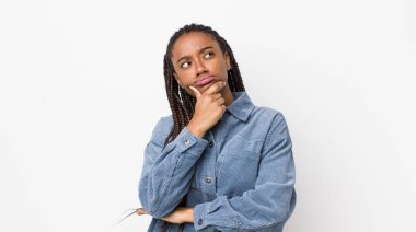 afro pretty woman thinking, feeling doubtful and confused, with different options, wondering which decision to make