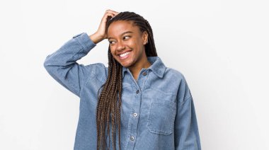 afro pretty woman smiling cheerfully and casually, taking hand to head with a positive, happy and confident look