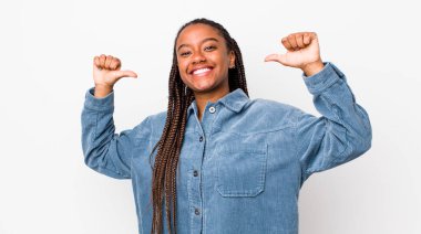 afro pretty woman feeling proud, arrogant and confident, looking satisfied and successful, pointing to self