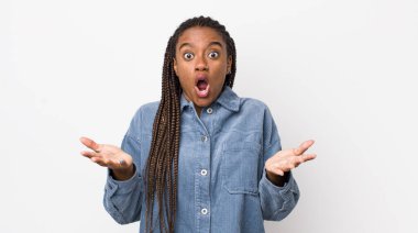 afro pretty woman feeling extremely shocked and surprised, anxious and panicking, with a stressed and horrified look