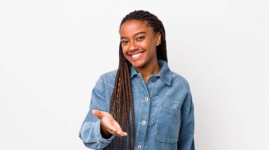 afro pretty woman smiling, looking happy, confident and friendly, offering a handshake to close a deal, cooperating