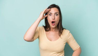 Genç ve güzel bir kadın mutlu, şaşkın ve şaşırmış görünüyor, gülümsüyor ve inanılmaz ve inanılmaz iyi haberleri fark ediyor.