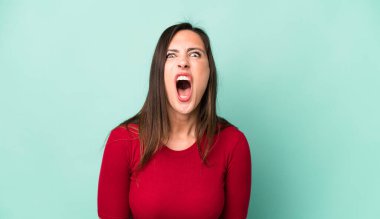 Genç ve güzel bir kadın agresif bir şekilde bağırıyor, sinirli, sinirli, öfkeli ya da sinirli görünüyor.