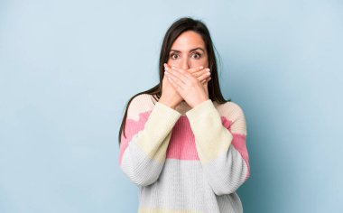 Genç ve güzel bir kadın elleri ile ağzını kapatıyor, şok olmuş, şaşırmış bir ifadeyle, sır saklıyor ya da 