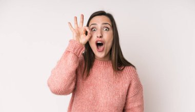 young adult pretty woman feeling successful and satisfied, smiling with mouth wide open, making okay sign with hand