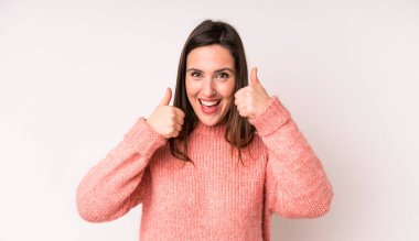 Genç ve güzel bir kadın gülümseyerek mutlu, pozitif, kendinden emin ve başarılı görünüyor.