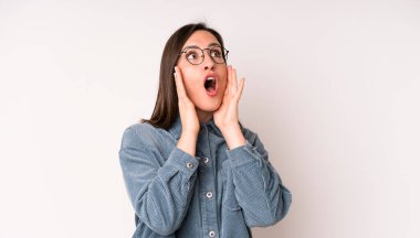 Genç ve güzel bir kadın mutlu, heyecanlı ve şaşırmış hissediyor. İki eli de havada bir tarafa bakıyor.