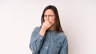 Genç ve güzel bir kadın iğreniyor, kötü ve nahoş bir koku duymamak için burnunu tutuyor.