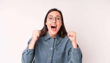 Genç ve güzel bir kadın mutlu, pozitif ve başarılı hissediyor, zaferi, başarıları veya iyi şansı kutluyor.