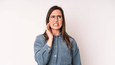 Genç, güzel bir kadın, yanağını tutuyor ve ağrılı diş ağrısı çekiyor. Hasta, sefil ve mutsuz hissediyor.