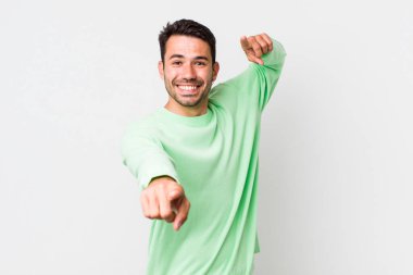 young handsome hicpanic man feeling happy and confident, pointing to camera with both hands and laughing, choosing you