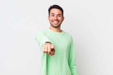 young handsome hicpanic man pointing at camera with a satisfied, confident, friendly smile, choosing you