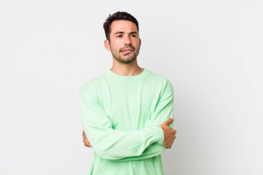 young handsome hicpanic man doubting or thinking, biting lip and feeling insecure and nervous, looking to copy space on the side