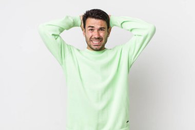 young handsome hicpanic man feeling stressed, worried, anxious or scared, with hands on head, panicking at mistake