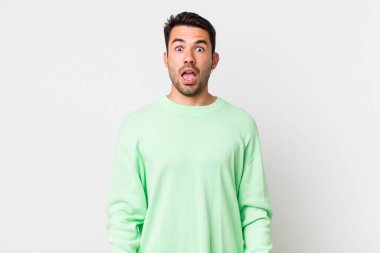 young handsome hicpanic man looking very shocked or surprised, staring with open mouth saying wow