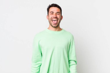 young handsome hicpanic man with cheerful, carefree, rebellious attitude, joking and sticking tongue out, having fun