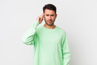 young handsome hicpanic man feeling confused and puzzled, showing you are insane, crazy or out of your mind