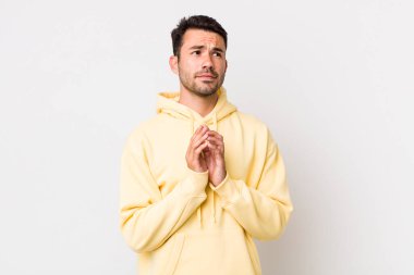 young handsome hicpanic man feeling proud, mischievous and arrogant while scheming an evil plan or thinking of a trick