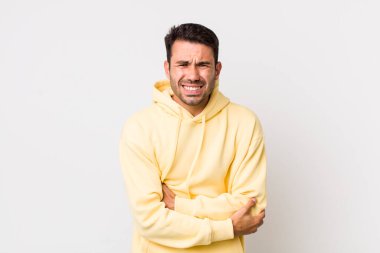 young handsome hicpanic man feeling anxious, ill, sick and unhappy, suffering a painful stomach ache or flu