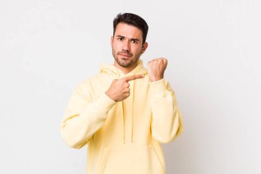 young handsome hicpanic man looking impatient and angry, pointing at watch, asking for punctuality, wants to be on time