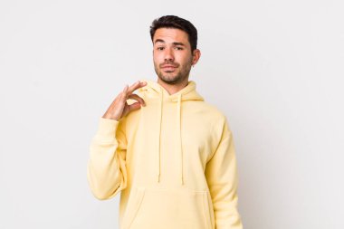 young handsome hicpanic man looking arrogant, successful, positive and proud, pointing to self
