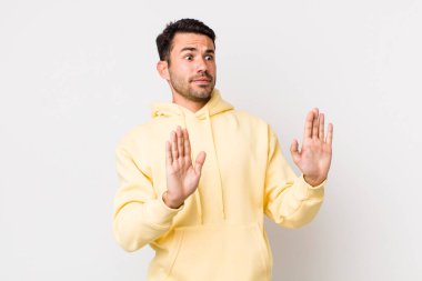 young handsome hicpanic man looking nervous, anxious and concerned, saying not my fault or I didnt do it 