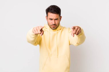 young handsome hicpanic man pointing forward at camera with both fingers and angry expression, telling you to do your duty
