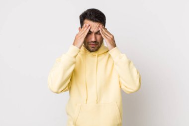 young handsome hicpanic man looking stressed and frustrated, working under pressure with a headache and troubled with problems