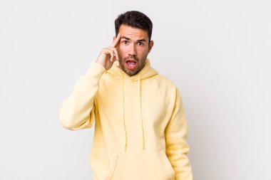 young handsome hicpanic man looking surprised, open-mouthed, shocked, realizing a new thought, idea or concept