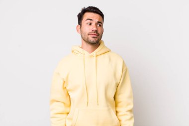 young handsome hicpanic man wondering, thinking happy thoughts and ideas, daydreaming, looking to copy space on side