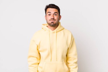 young handsome hicpanic man with a goofy, crazy, surprised expression, puffing cheeks, feeling stuffed, fat and full of food