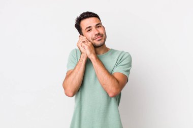 young handsome hicpanic man feeling in love and looking cute, adorable and happy, smiling romantically with hands next to face