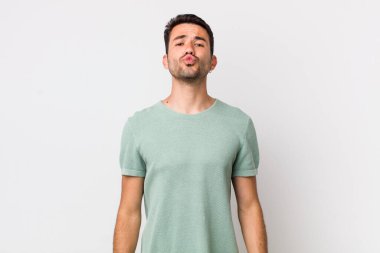 young handsome hicpanic man pressing lips together with a cute, fun, happy, lovely expression, sending a kiss