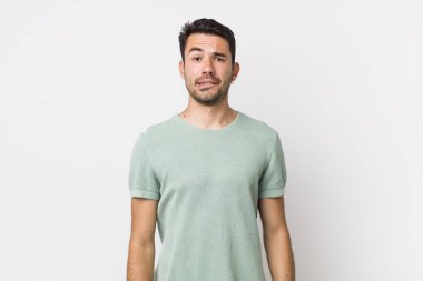 young handsome hicpanic man feeling clueless, confused and uncertain about which option to pick, trying to solve the problem
