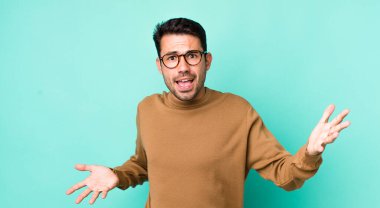 young handsome hicpanic man looking happy, arrogant, proud and self satisfied, feeling like a number one