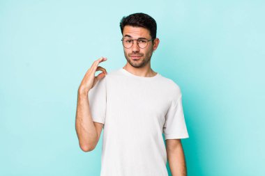 young handsome hicpanic man looking arrogant, successful, positive and proud, pointing to self